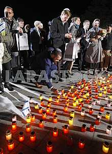 People light candles and lay flowers