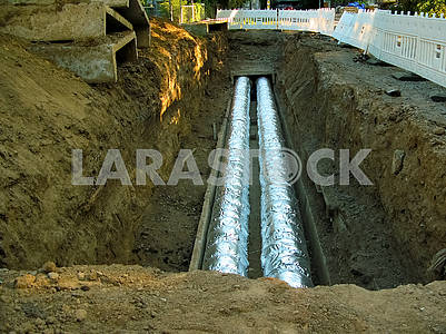 Замена и изоляция больших водопроводных труб в земле.