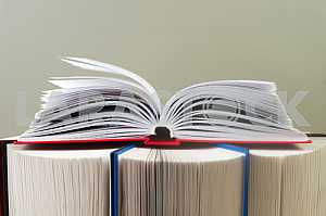 Открытая книга, стопка книг в твердом переплете на деревянном столе. Обратно в школу. Копирование пространства