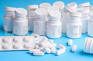 Many pills and tablets isolated on light blue background