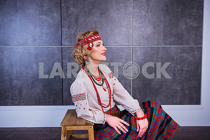 A beautiful girl in National Ukrainian Costume. captured in studio. Embroidery and jacket. wreath. red lips. light. historical costume. Nationality - ukrainian