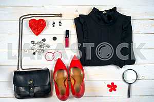 Women clothing set and accessories on white wooden background.
