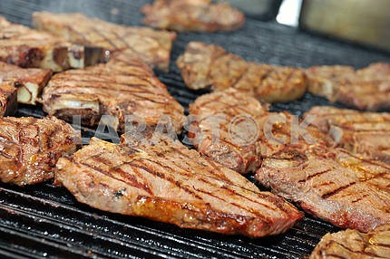 t-bone steak cooking on an open flame grill
