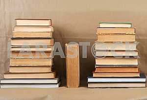 Old and used hardback books or text books on wooden table. Books and reading are essential for self improvement, gaining knowledge and success in our careers, business and personal lives. Copy space