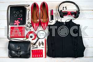 Women clothing set and accessories on white wooden background.