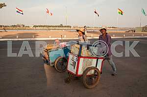 Two girls with wheelbarrows for sale