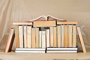Old and used hardback books or text books on wooden table. Books and reading are essential for self improvement, gaining knowledge and success in our careers, business and personal lives. Copy space