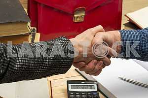 On a wooden table books, documents, calculator, red briefcase.