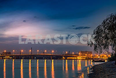 Beautiful background sunset on the river with views of the illuminated lights Bridge