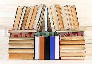 Открытая книга, стопка книг в твердом переплете на деревянном столе. Обратно в школу. Копирование пространства