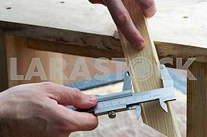 Different construction tools on a wooden background - screwdriver, caliper.