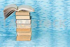 Old and used hardback books or text books on wooden table. Books and reading are essential for self improvement, gaining knowledge and success in our careers, business and personal lives. Copy space