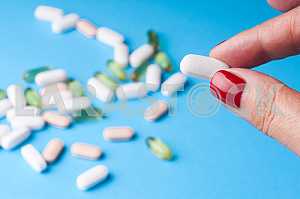Many pills and tablets isolated on light blue background