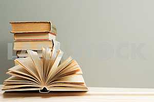Stack of hardback books on blue cloth. Back to school. Copy space