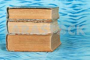 Old and used hardback books or text books on wooden table. Books and reading are essential for self improvement, gaining knowledge and success in our careers, business and personal lives. Copy space