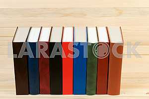 Open book, stack of hardback books on wooden table. Back to school. Copy space