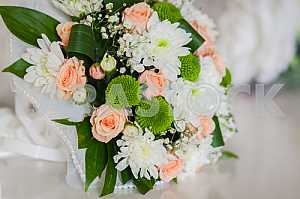 Wedding bouquet made of roses, chrysanthemum and laying on the white box