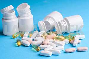 Many pills and tablets isolated on light blue background