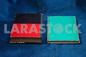 Open book, stack of hardback books on wooden table. Back to school. Copy space