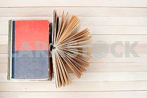 Stack of hardback books on blue cloth. Back to school. Copy space