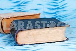 Old and used hardback books or text books on wooden table. Books and reading are essential for self improvement, gaining knowledge and success in our careers, business and personal lives. Copy space