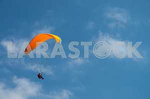 Paraglider flying over mountains on a summer day