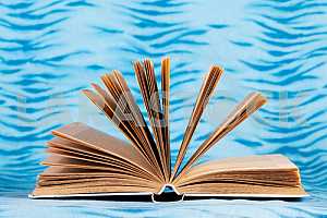 Old and used hardback books or text books on wooden table. Books and reading are essential for self improvement, gaining knowledge and success in our careers, business and personal lives. Copy space