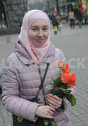 Участница акции держит цветы