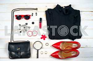 Women clothing set and accessories on white wooden background.