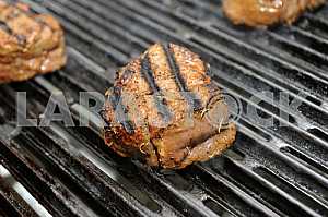Beef steak cooking on an open flame grill