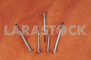 Different construction tools on a wooden background - screwdriver, caliper.
