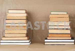 Old and used hardback books or text books on wooden table. Books and reading are essential for self improvement, gaining knowledge and success in our careers, business and personal lives. Copy space
