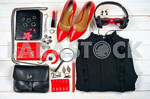 Women clothing set and accessories on white wooden background.