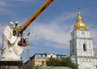 A cleaning company employee washes a monument to Cyril and Methodius