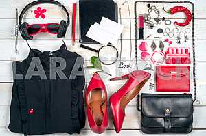 Women clothing set and accessories on white wooden background.