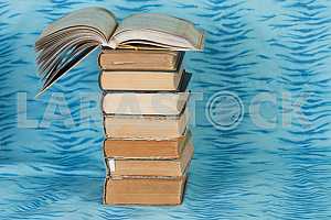 Old and used hardback books or text books on wooden table. Books and reading are essential for self improvement, gaining knowledge and success in our careers, business and personal lives. Copy space