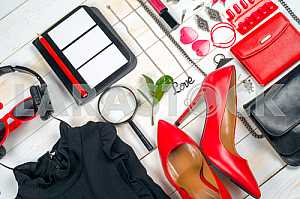 Women clothing set and accessories on white wooden background.