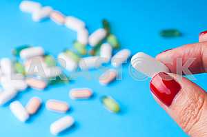 Many pills and tablets isolated on light blue background