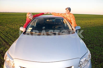 Happy young couple with new car