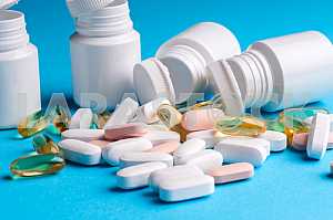 Many pills and tablets isolated on light blue background