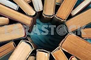 Old and used hardback books or text books on wooden table. Books and reading are essential for self improvement, gaining knowledge and success in our careers, business and personal lives. Copy space