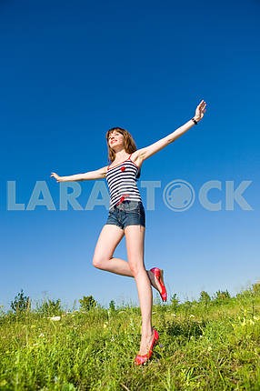 Happy young woman enjoying summer. Against the backdrop of blue 