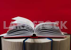 Открытая книга, стопка книг в твердом переплете на деревянном столе. Обратно в школу. Копирование пространства