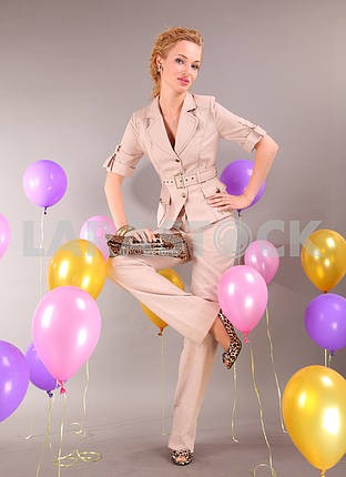 Beautiful young girl in light dress on background balloons