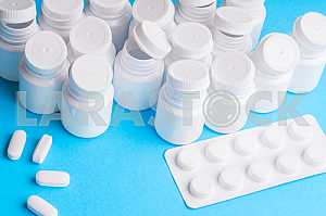 Many pills and tablets isolated on light blue background