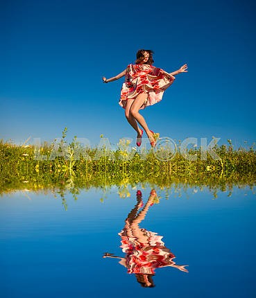 Happy young woman jumping in a field