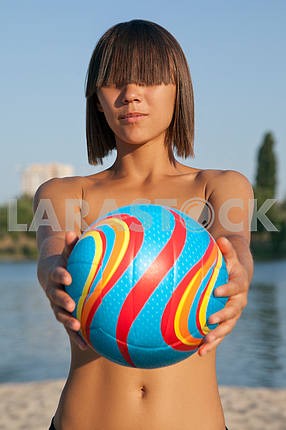 Young beautiful lady is holding volleyball ball