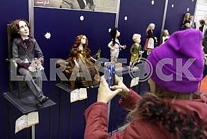 The girl photographed on a mobile phone doll on the stand