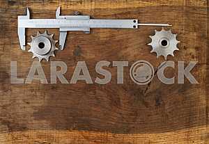 Different construction tools on a wooden background - screwdriver, caliper.