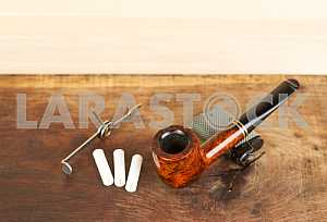Smoking pipe on a wooden table. Aroma. Copy space